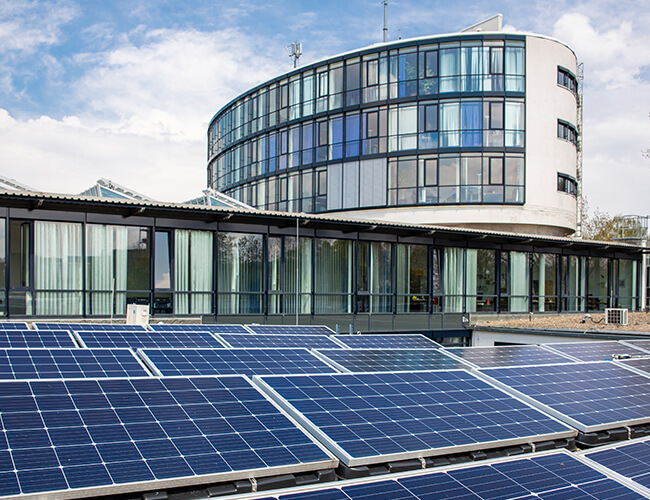 Das Bild zeigt die Außenansicht der Stadtwerke Witten mit einer beeindruckenden Photovoltaikanlage, die sich auf dem Gelände des Unternehmens befindet.